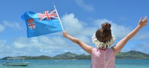 girl on beach waving Fiji flag